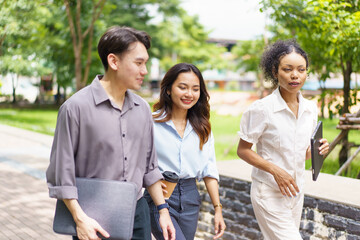 Graduate students or businesspeople discussing together in the park.