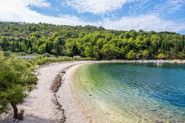 Stunning Adriatic coastline with crystal-clear turquoise waters, rocky shoreline, lush Mediterranean greenery, and a peaceful secluded beach