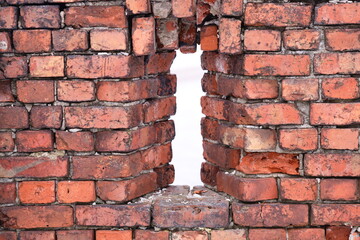Fototapeta premium A worn-out brick wall with a large hole in it, possibly from demolition or decay.