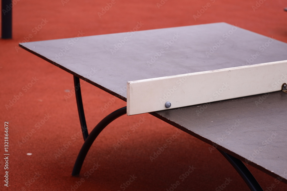Poster a ping pong table situated on a bright red floor, perfect for a game or event.