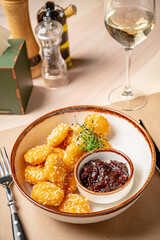Savory golden morsels placed elegantly on a plate, paired with a tangy sauce and garnished