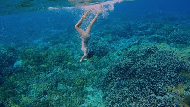 Beautiful woman snorkeling in transparent water of ocean, Bali, Indonesia