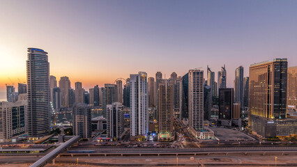 Dubai marina with traffic on sheikh zayed road panorama day to night timelapse lights turn on.