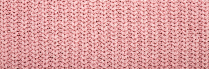 Light pastel pink soft knitted fabric pattern background. Closeup. Wide banner. Top down view.