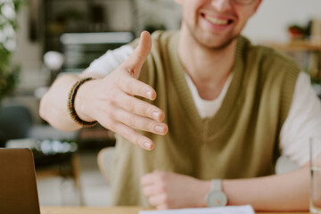 Medium close up of unrecognizable job interviewer giving hand to greet