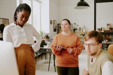 Medium close up of biracial office workers focused on presentation on computers screen in office...