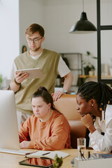 Vertical shot of African American and Caucasian programmers cooperating during work day in office