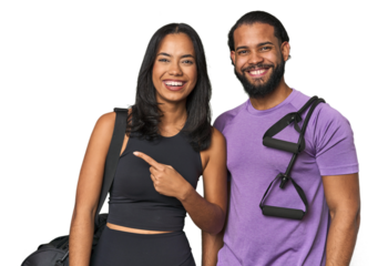 Young Latino couple ready for gym training smiling and pointing aside, showing something at blank space.