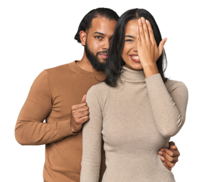 Young Latino couple in studio having fun covering half of face with palm.