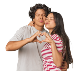 Joyful multiracial couple forming a heart with hands in studio