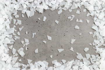 Close-up of magnesium flakes on gray concrete background, salt crystalline texture. Natural White...