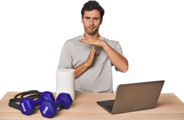 Hispanic trainer planning workout showing a timeout gesture.