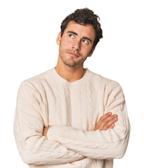 Young Hispanic man in studio dreaming of achieving goals and purposes
