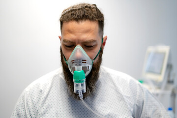 Patient wearing an oxygen mask with nebulizer undergoing respiratory therapy in hospital room