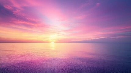 Fototapeta premium A stunning sunset with vibrant pink and purple hues reflecting on calm ocean waters.