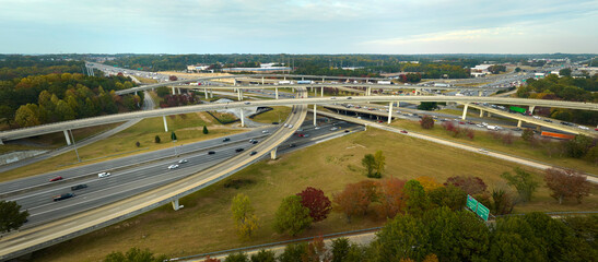 American freeway intersection with fast driving cars and trucks. View from above of USA transportation infrastructure