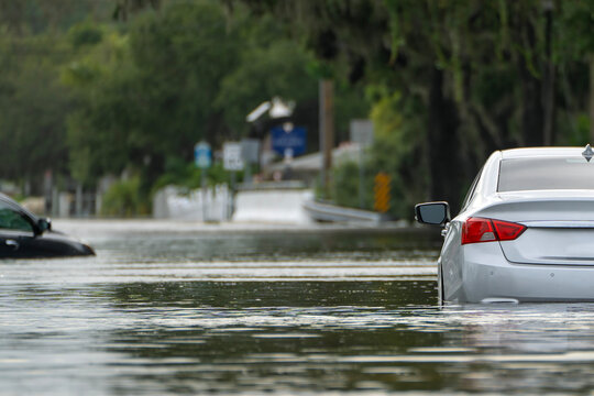 Flooded road with sunken cars in surrounded with water Florida residential area. Consequences of hurricane Debby natural disaster