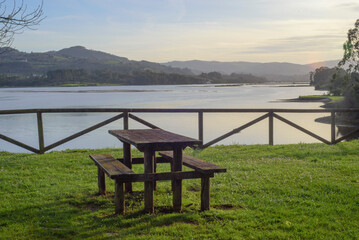 Mesa y bancos de picnic junto a la ría de Villaviciosa, Asturias