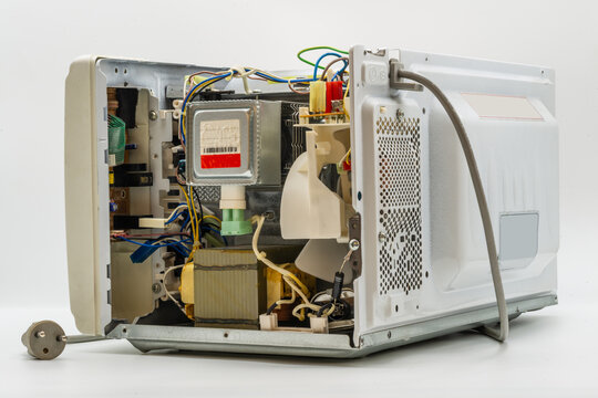 Disassembly of a microwave oven revealing internal components and wiring details