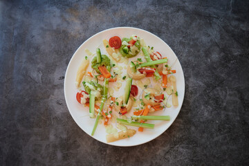 A plate of food with a variety of vegetables including carrots, celery