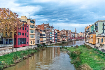 Panoramic view of Girona, Spain, showcasing the colorful houses along the Onyar River. The autumnal...