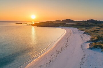 A golden sunset illuminates a tranquil beach with soft waves and sand
