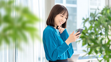 スマートフォンを使う笑顔の女性・ビジネスウーマン