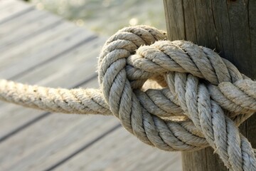 Knot Tied in a Rope Securing It to a Wooden Post Near Water in Low Resolution Generative AI