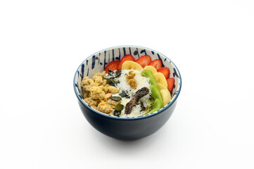 A bowl of food with a banana, strawberry, and walnuts