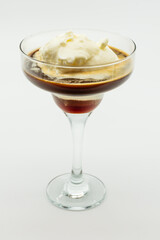 A glass of ice cream with a scoop of ice cream on top