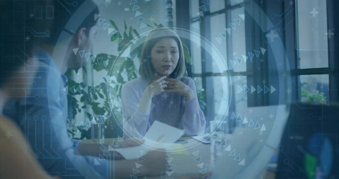 In meeting, professionals discussing documents with digital interface overlay in office