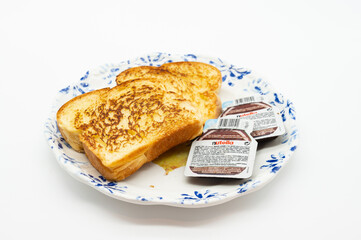 A plate with two pieces of toast and a jar of Nutella