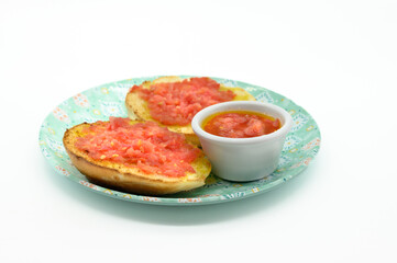 A plate with two slices of bread and a small bowl of sauce