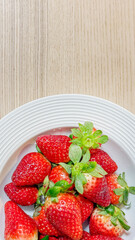 Fresh ripe strawberries on a white plate, summer harvest, healthy dessert, delicious fruit snack