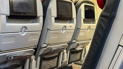 Airplane seats with personal screens, travel comfort, modern aviation technology, passenger...