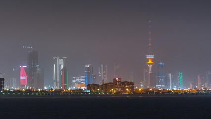 Skyline with Skyscrapers night timelapse in Kuwait City downtown illuminated at dusk. Kuwait City, Middle East
