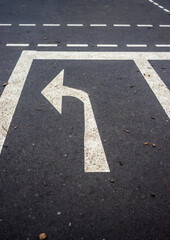 A white arrow pointing to the left is on a black road