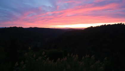 Obraz premium Vibrant Sunset over Hilly Landscape