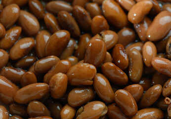 Brown beans basking in natural light, highlighting their smooth texture and rich color in a...