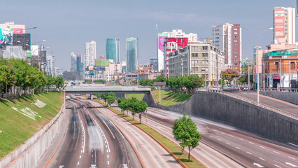 Obraz premium Aerial view of Via Expresa highway and metropolitan bus with traffic timelapse and blue sky with clouds. Lima, Peru