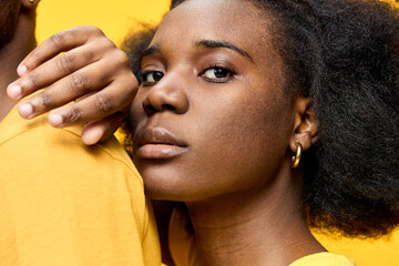 Portrait of a young Black woman with natural hair, wearing a yellow shirt, showcasing confidence...