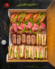 Assorted gourmet sandwiches in a box, ideal for lunch gatherings, picnics, and catering events