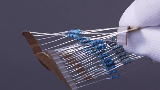Close-up of a THT 1/4W resistor with a color-coded band pattern, positioned on a dark background. A classic electronic component used in Through-Hole Technology (THT) assembly. Ideal for applications