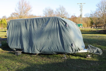 a caravan with a gray tarpaulin