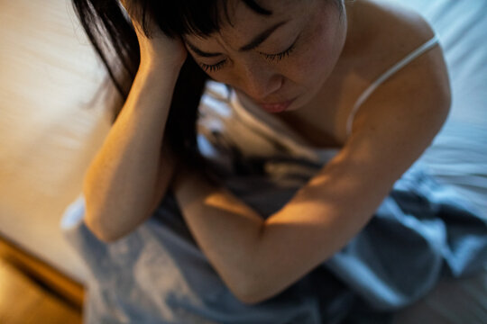 Stressed woman sitting in bed with anxiety