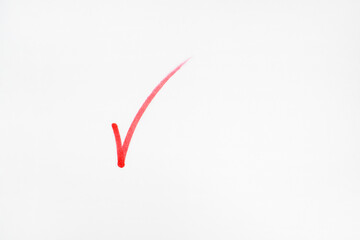 A simple, bold red check mark drawn on a clean white background, symbolizing completion, approval,...