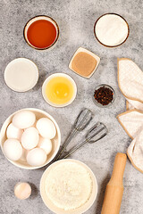 Kitchen background of food preparation.Culinary ingredients for making pie and bread,recipe with eggs,flour,sugar,honey,cinnamon,yeast and butter.Concept of modern bakery