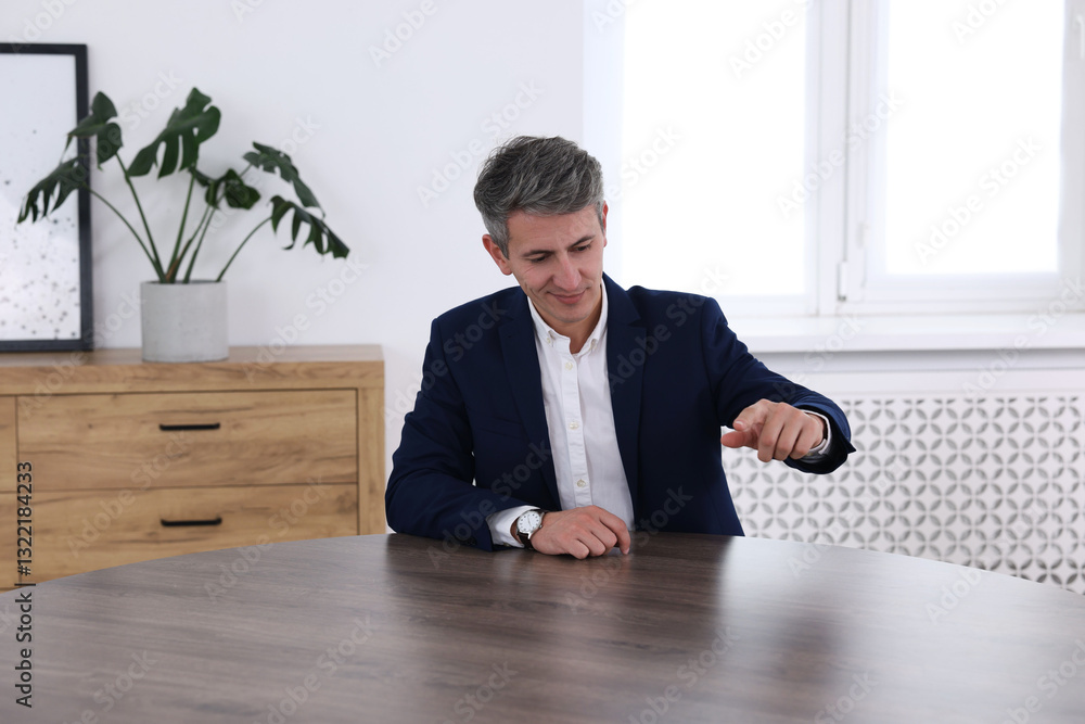 Poster man pointing at something on desk in office