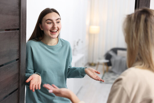Surprised woman welcoming guest to her apartment
