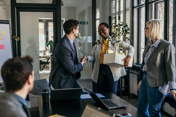 A group of coworkers is saying goodbye to an old colleague who is leaving the office. Concept of losing a job